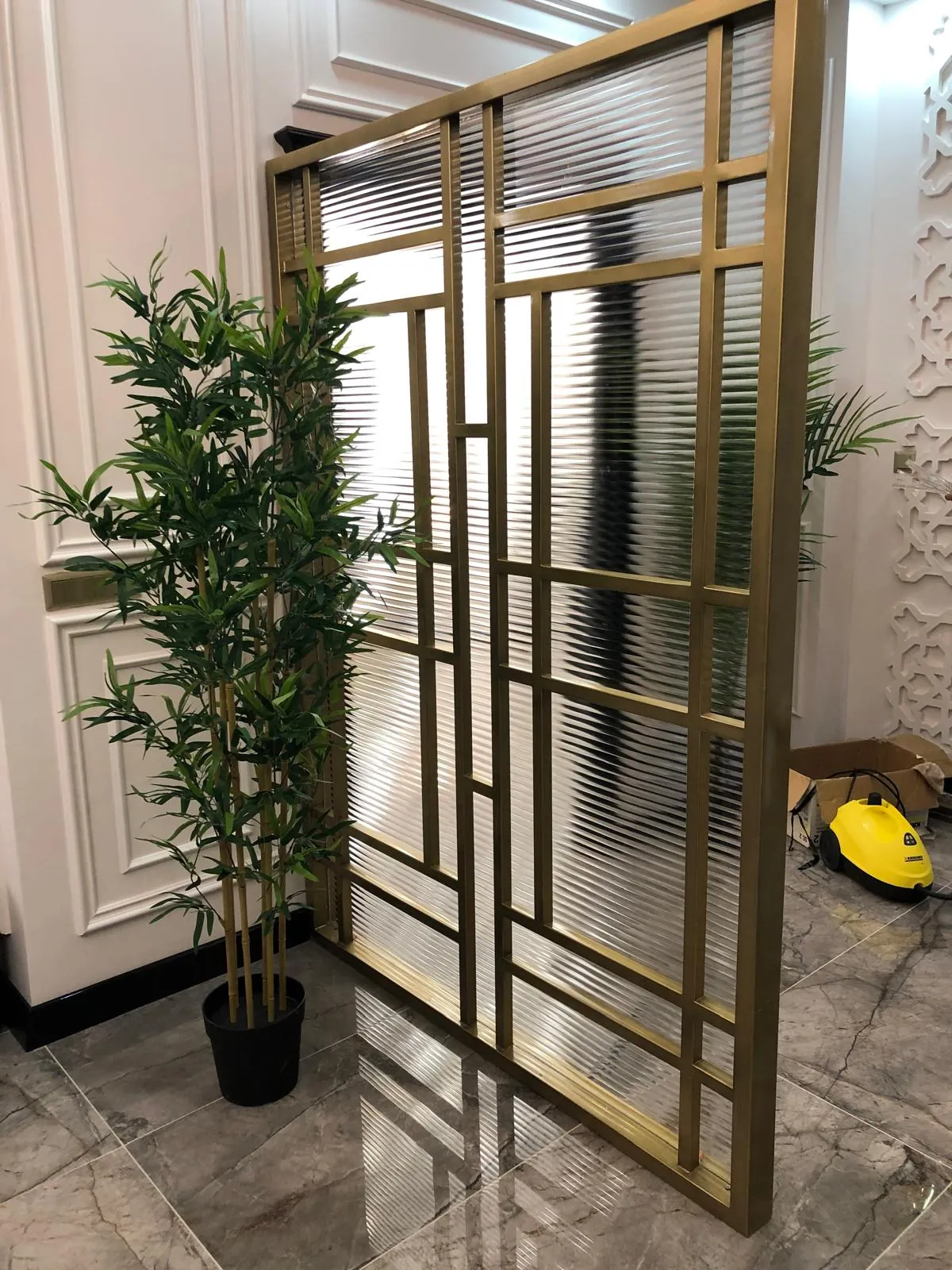 Pirinç tonlu geometrik profil desenli, yivli camlı metal paravan
